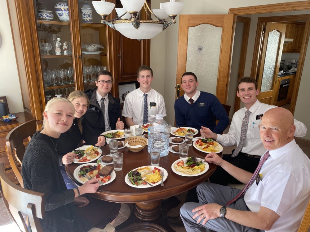 Missionaries sharing a meal with ward members